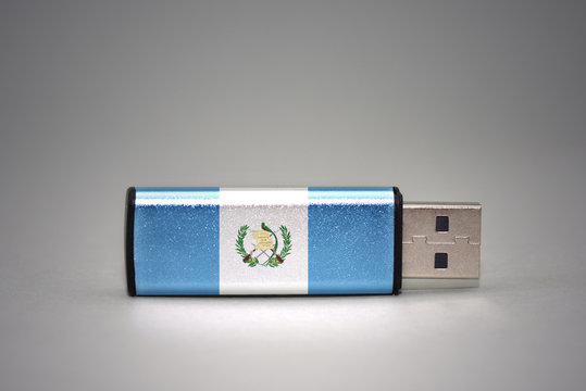 usb flash drive with the national flag of guatemala on gray background.