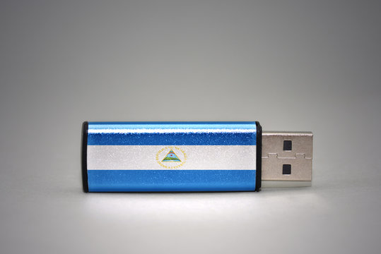 usb flash drive with the national flag of nicaragua on gray background.