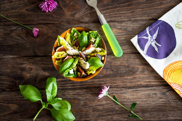 Homemade salad with figs, goat cheese and pine nuts on wooden background