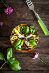 Homemade salad with figs, goat cheese and pine nuts on wooden background
