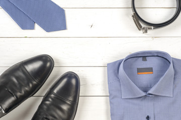 set of men's clothing and shoes on wooden background.