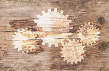 Illustration of gears at brown wooden background
