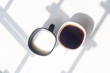 black and white cup of milk, coffee on natural background, top view