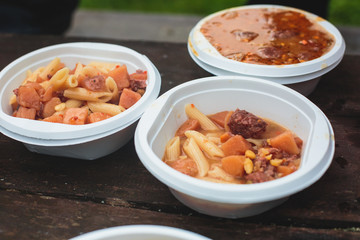 A concept of cooking field red colored meat soup on a bonfire or portable gas stove on camping in Norway