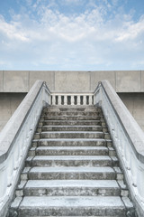 Fototapeta premium Bottom view stairs of white stonemason bridge against the blue cloudy sky during summer day