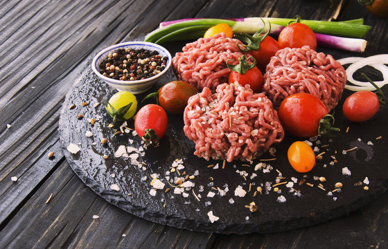 raw minced meat, vegetables with salt and spices, selective focus