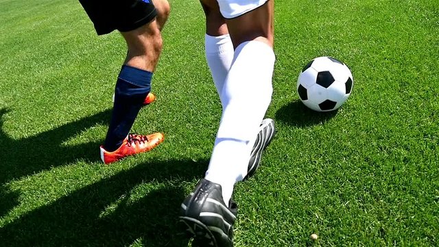 Footballer making tricks to avoid the defender, slow motion