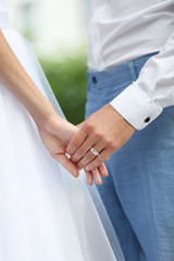 Obraz na płótnie Canvas Bride and groom holding hands together outdoor