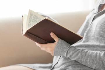 Woman reading old book at home