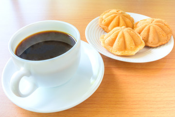Coffee and flower shape bread on wooden table