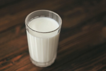 Glass of fresh milk on wooden background