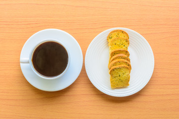Black coffee and garlic bread on top side view