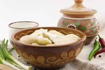 Dumplings with sour cream in ceramic bowl. 