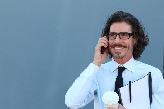 Horizontal portrait of a Caucasian middle-aged handsome man wearing a shirt and tie while having a pleasant conversation on the mobile phone with copy space
