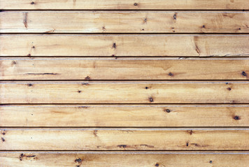 The walls are made of wooden planks with traces of paint. The texture of the wooden planks as a background with a copy of the space