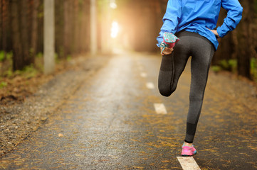 Running stretching - runner wearing smartwatch.