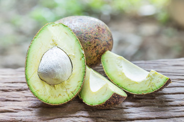 Avocado on a wooden floor and has a background of nature