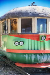 Vintage electric train. Times of the USSR. Rusty, shabby, old electric train. With round headlights and wooden windows.