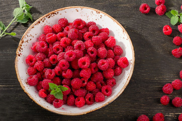 Fresh raspberries on a rustic wooden background.
