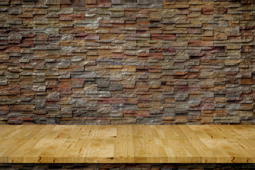 Empty top wood bench plans in front of a sand stone wall.background. For montage product display