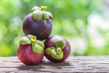 Fresh mangosteen on a wooden floor and has a background of natur