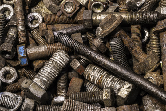 Selection of old rusty  nuts and bolts in container 
