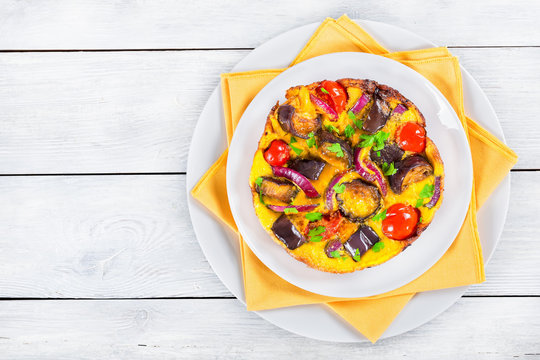 frittata with red onion, eggplant, tomato sprinkled with parsley