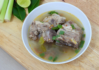 white bowl of hot and spicy pork bone soup  on wood background.