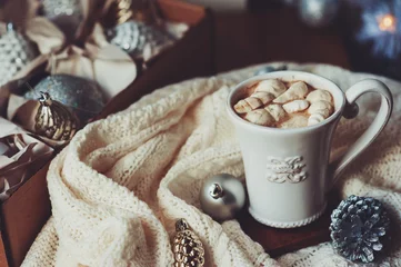 Foto op Canvas cup of hot cocoa with marshmallow with Christmas decorations at home, Christmas tree on background, cozy mood © mashiki