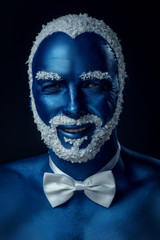 Man painted in blue color with snowy hair and beard on black background