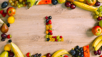 Fruits made letter L. The composition of bright ripe fruits. Alphabet on a table. L - 120660388