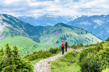 Fototapeta premium Hiker in beautiful landscape of Alps in Germany - Hiking in the