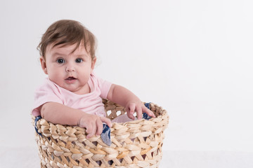 chillendes Baby in Korb mit rosa Blumen