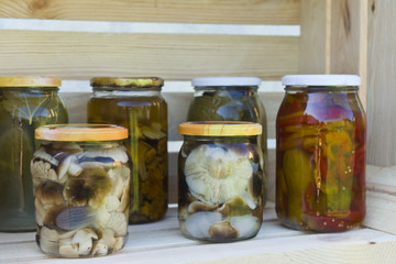 Preserving pickled cucumbers and mushrooms. Pickles jars.