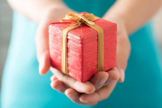Woman holding red gift box by hand