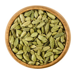 Cardamom pods in a wooden bowl on white background. Light green processed pods of Elettaria cardamomum, dried seeds, used as flavorings, spice and as medicine. Isolated macro photo close up from above