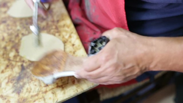 Calzolaio al Lavoro nella sua bottega artigianale. Incollatura suola per scarpe da donna. 