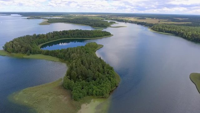 View of small islands on the lake in Masuria and Podlasie district, Poland. Blue water and whites clouds. Summer time. View from above.