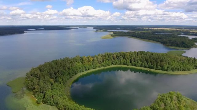 View of small islands on the lake in Masuria and Podlasie district, Poland. Blue water and whites clouds. Summer time. View from above.