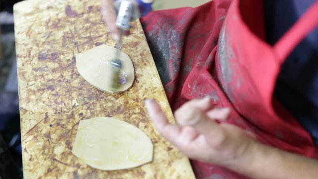 Calzolaio al Lavoro nella sua bottega artigianale. Incollatura suola di una scarpa. 