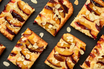 Slices of plum pie on black background.