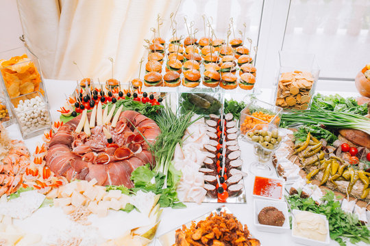 Buffet table of reception with burgers, cold snacks, meat and salads