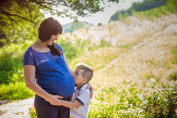 Fototapeta premium little boy hugging pregnant mother
