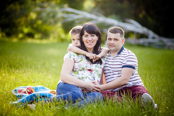 Fototapeta premium Happy Family portrait Father, pregnant mother and son