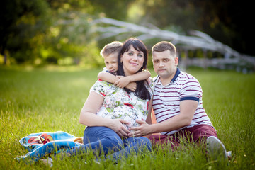 Fototapeta premium Happy Family portrait Father, pregnant mother and son