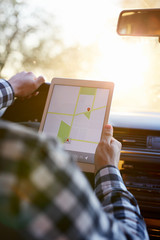 Man sitting in car and holding tabletnavigation