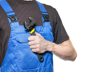 Man mechanic in working clothes holds a wrench in his hand isolated on white background