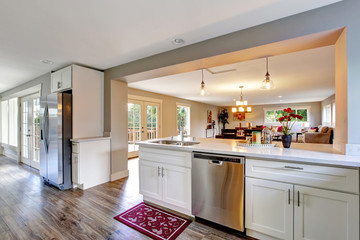 Open floor plan white kitchen room with polished hardwood floor