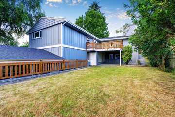 Spacious wooden fenced backyard area. Countryside blue house.