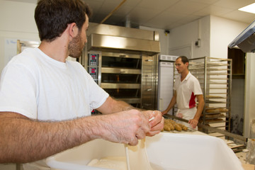 Collaboration of two men in the laboratory of a bakery shop